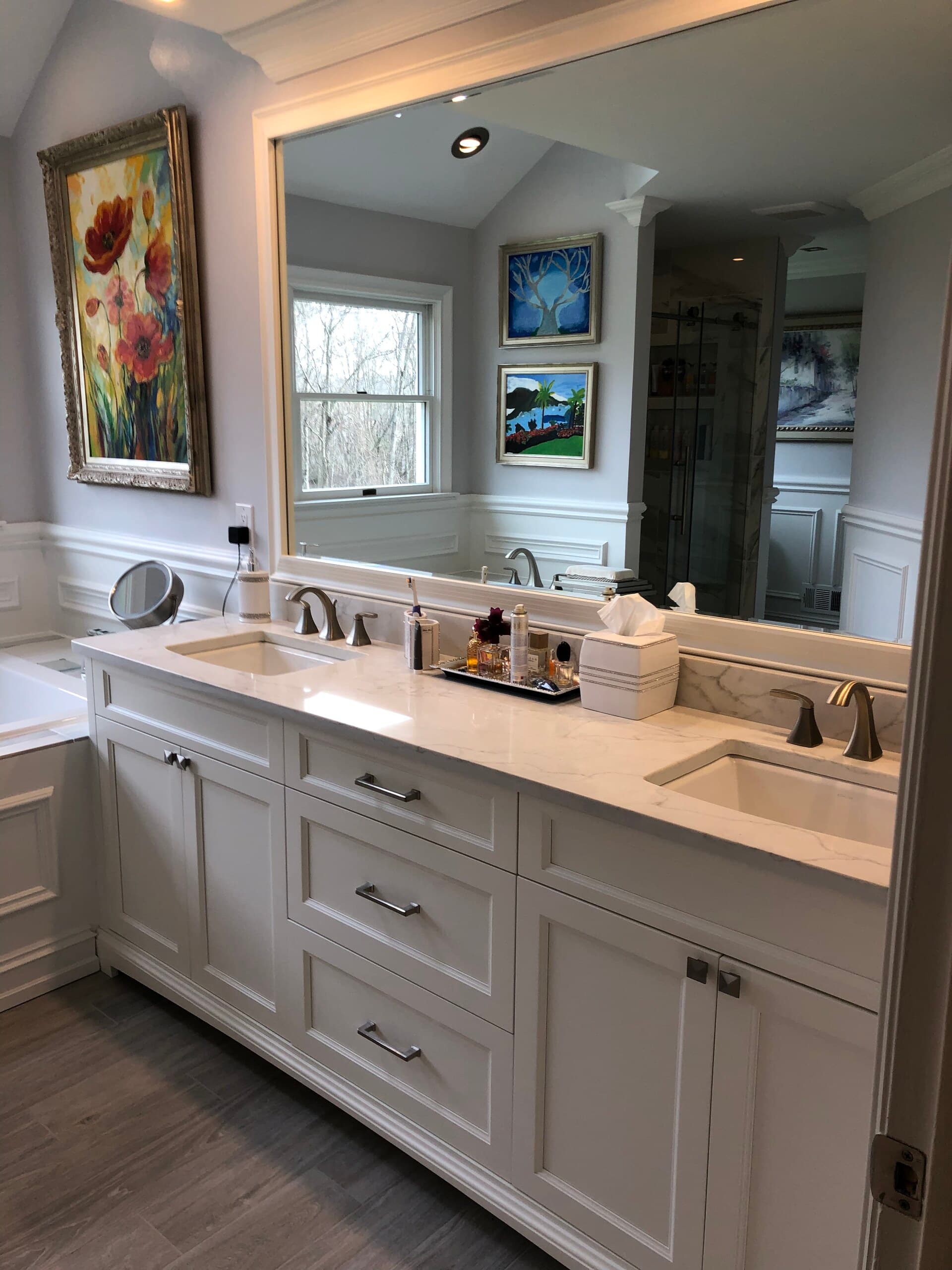 Bathroom remodel with a white double vanity, quartz top and a full-width mirror