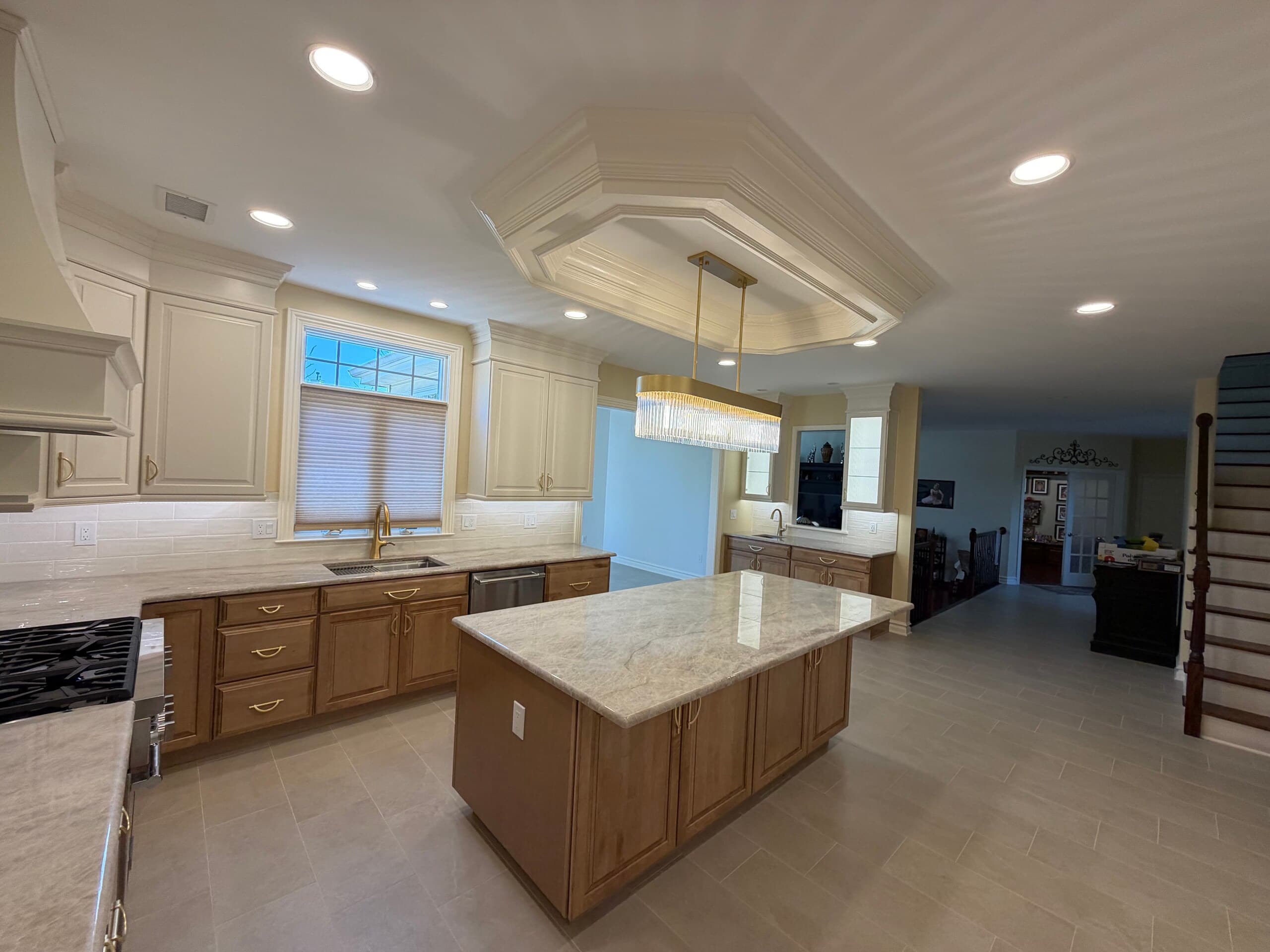 Open-plan kitchen remodel with a center island, coffered ceiling detail and pendant lighting